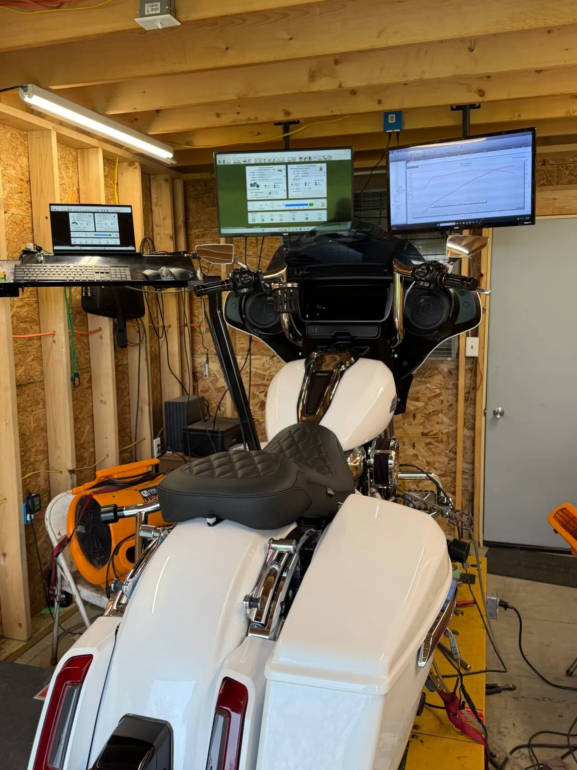 White Harley bagger strapped to the dyno in the FKN Performance dyno room, tuning screens above