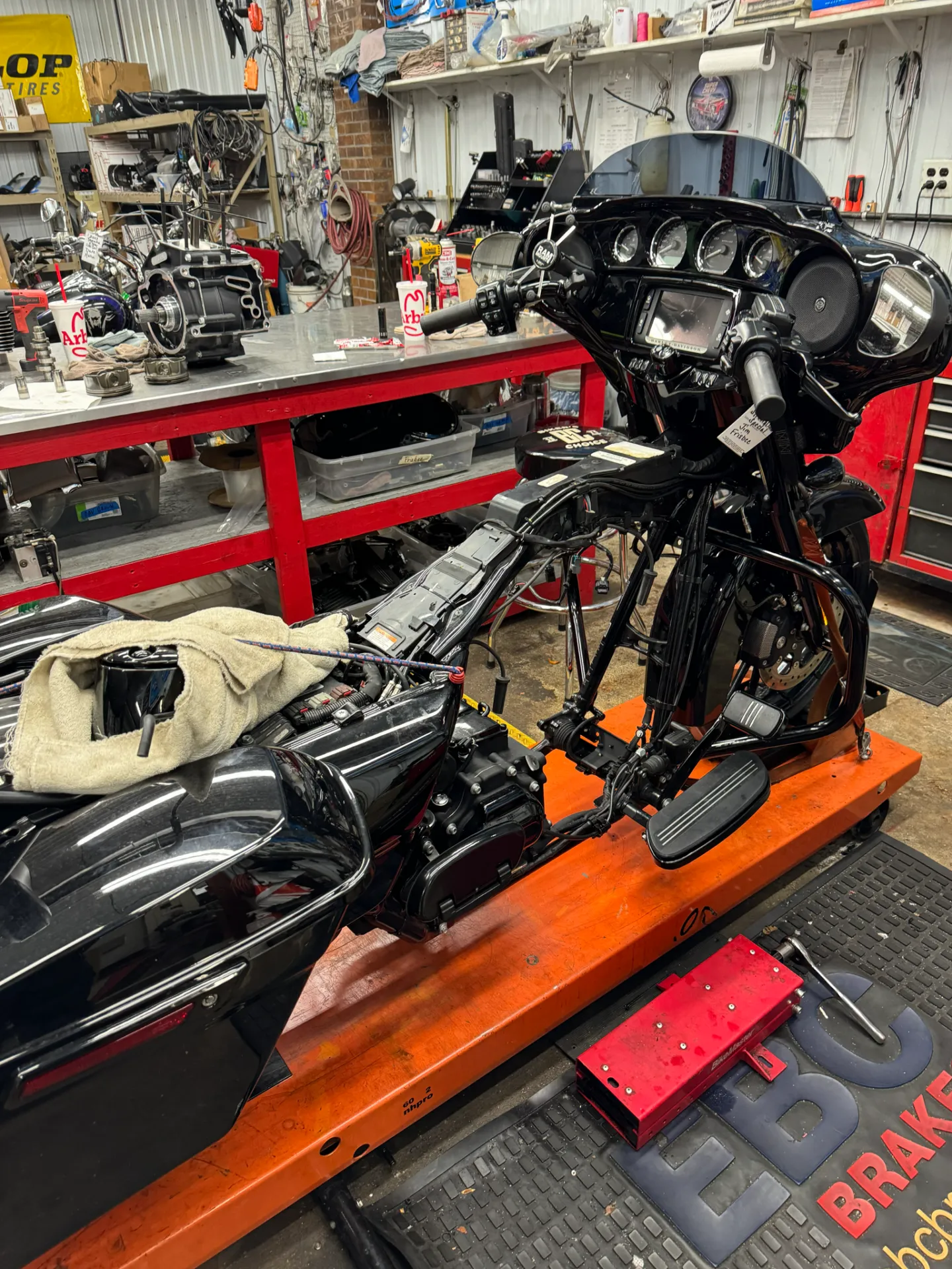 Harley bagger on a lift in the shop with its engine being rebuilt